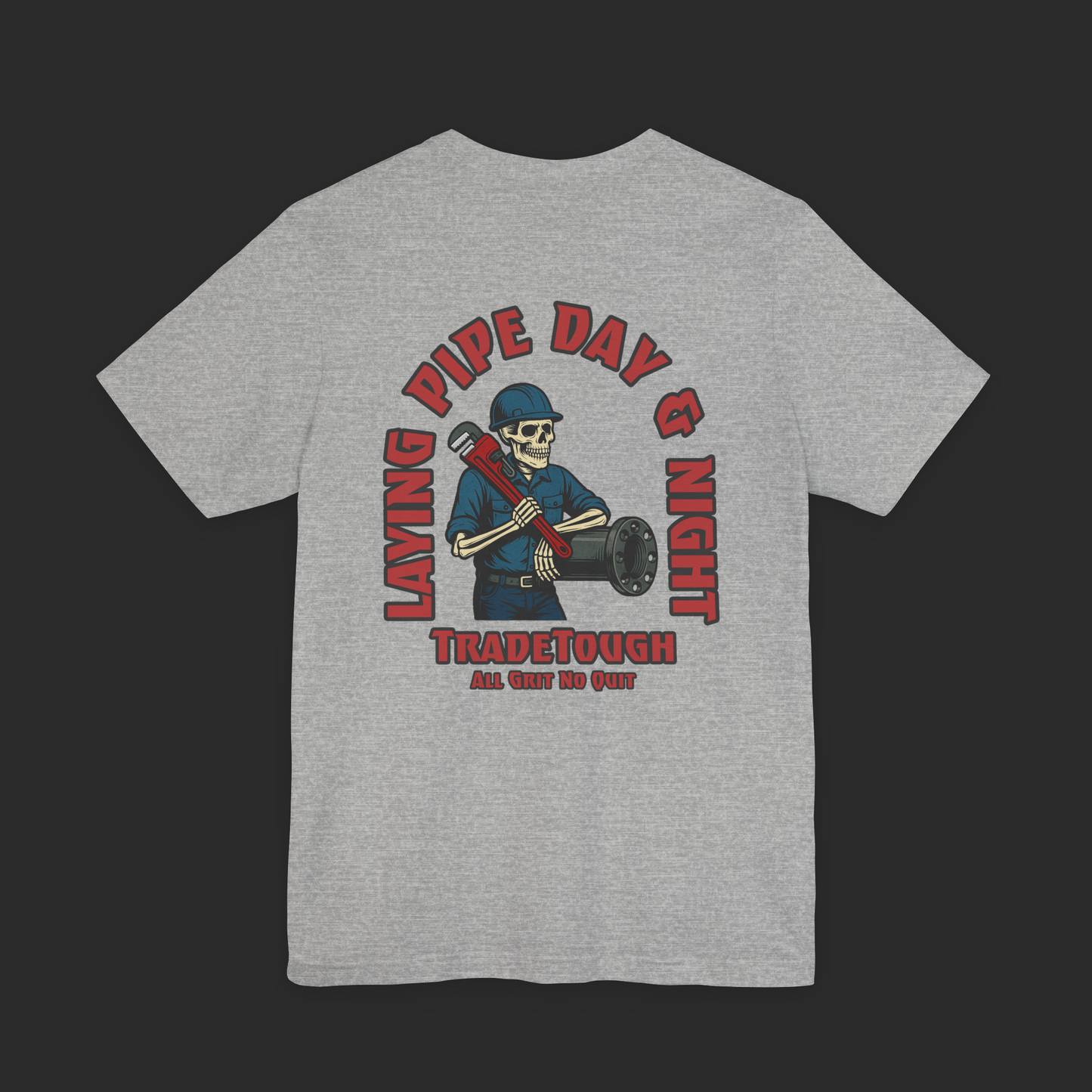 Gray t-shirt with a graphic design on the back featuring a skeleton wearing a hard hat and holding pipes, with text 'Laying Pipe Day & Night' and 'Tradetough'.