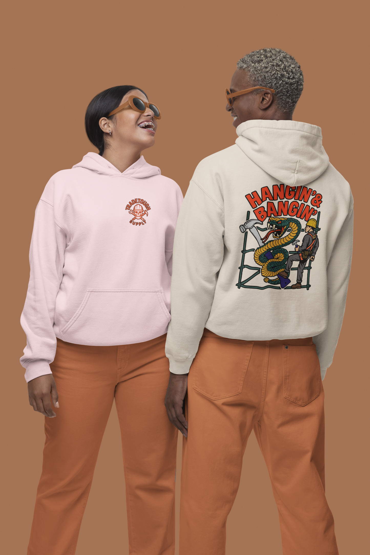 Two models wearing Hangin’ & Bangin’ Gildan hoodies – front and back view showing bold scaffold graphic and chest logo
