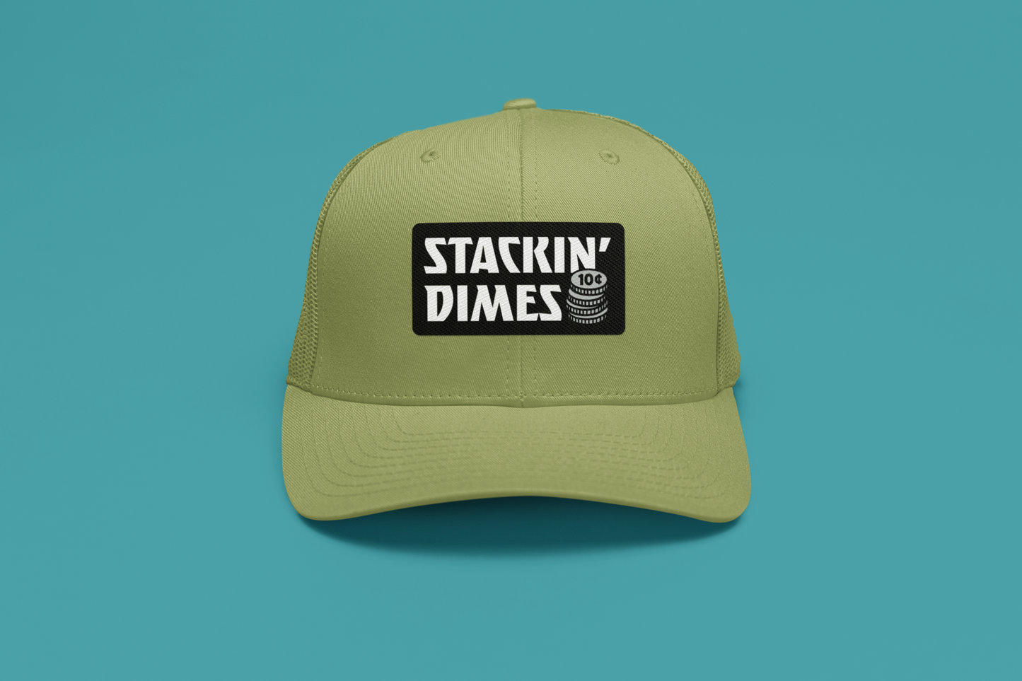 Green cap with 'Stackin' Dimes' logo on a teal background